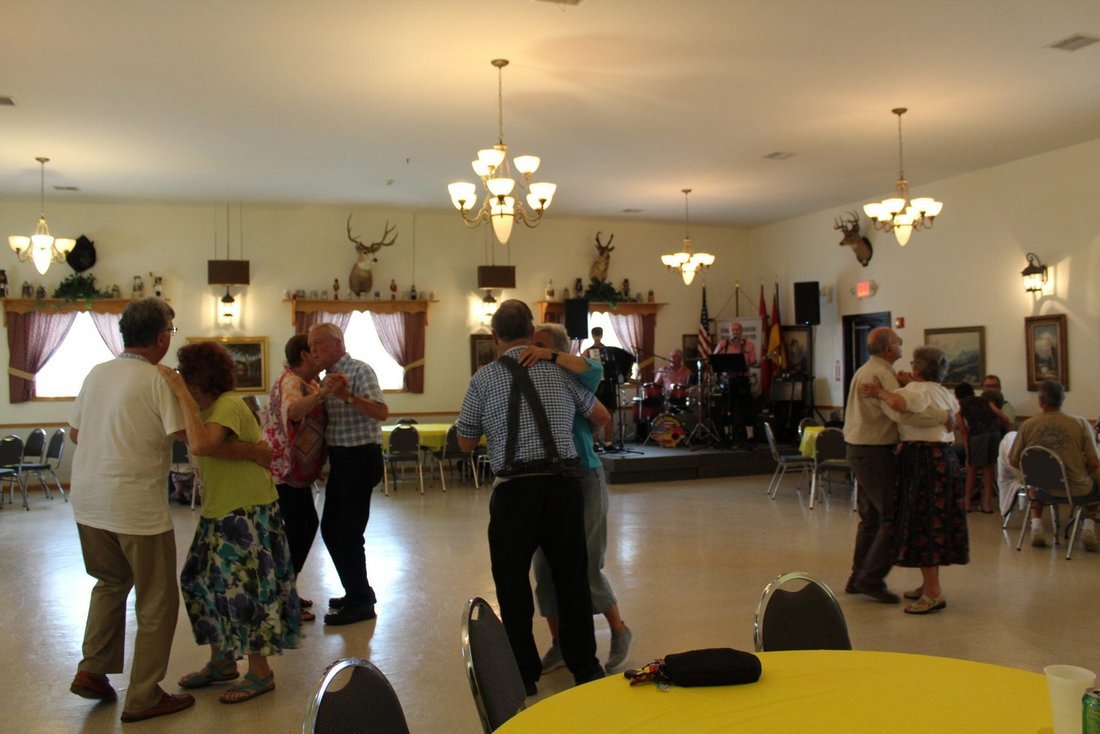 Couples dancing in a German-American hall while the band plays on stage