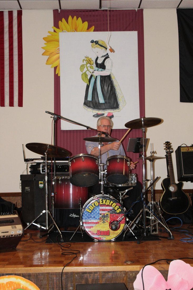 John Gunther behind the red Euro Express drum kit on a fest hall stage