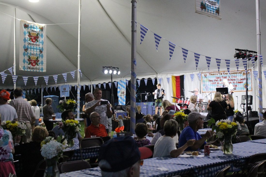 Inside the Itasca Oktoberfest tent — long tables, Bavarian bunting, and the band on stage
